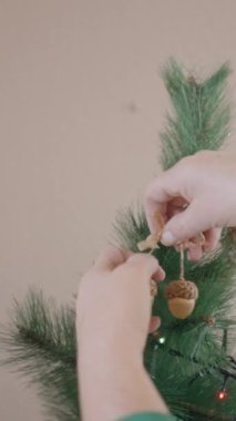 Noel ağacına mısır süsü takan bir kadının kesilmiş görüntüsü. Kapat - Dikey FullHD videosu