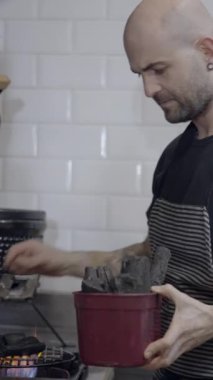 Şef restoranın mutfağına, yan tarafına mangal kömürü koyar - FullHD dikey video