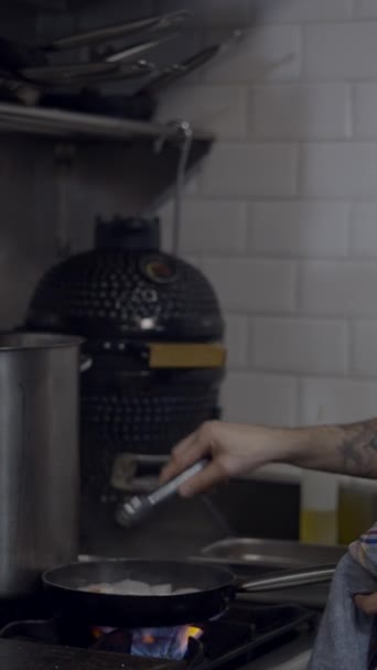 餐厅厨房中围裙火爆食品中男性厨师的侧视图 Fullhd垂直视频 — 图库视频影像