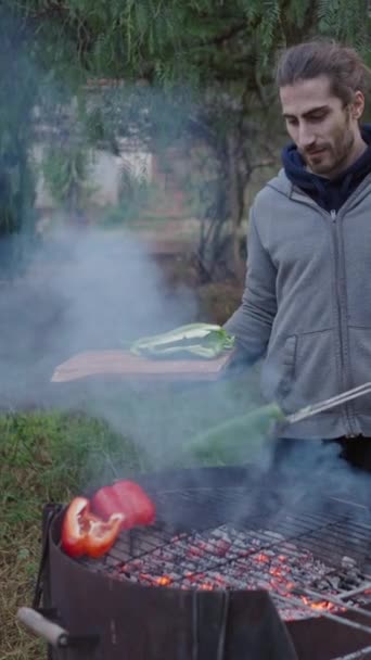 Άνδρας Άνετα Ρούχα Μαγειρεύει Λαχανικά Στο Σπίτι Του Στο Δάσος — Αρχείο Βίντεο