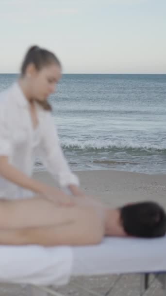 Man Ligt Neer Massagetafel Aan Het Strand Ongefocust Met Zee — Stockvideo