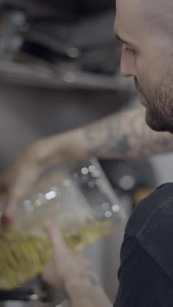 レストランキッチンに食品油を注ぐ男性シェフの側面ビュー フルHd垂直ビデオ — ストック動画