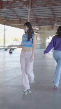 Üç kız paten kayarken ters yönde, Slomo FullHD dikey video.