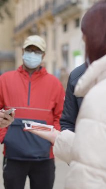 Güneşli bir günde buradan geçen yerel halka kartlarla sokak sihirbazlığı numarası yapan bir erkek sihirbazın yakın görüntüsü. - FullHD dikey video