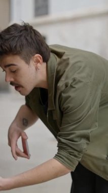 Yerel halkla etkileşim içinde olan bir erkek sihirbazın, arka plandaki kaldırımın üzerinden geçen yerel halkla sihir numaraları gösterirken yakın plan görüntüsü. - FullHD dikey video