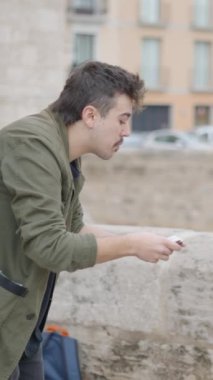 Sihirbaz adam kartlarla sokak sihirbazlığı numarası yapıyor. İki kız sokağın köşesindeki sihirbazlık numarasından zevk alıyor. - FullHD dikey video