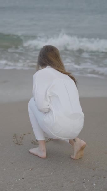 Die Rückansicht Einer Unkenntlichen Frau Schreibt Wort Den Sand Strandwellen — Stockvideo
