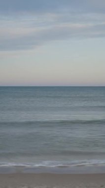 Plajda çalışan masaj terapistinin görüntüsü, deniz dalgaları ve masaj yapan kadının görüntüsü.