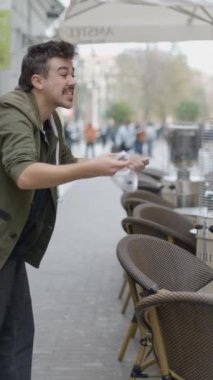 Sihirbaz sokak sihirbazlığı numarası yapıyor. Bir sokak sihirbazı kişniş şapkasını takar FullHD dikey video