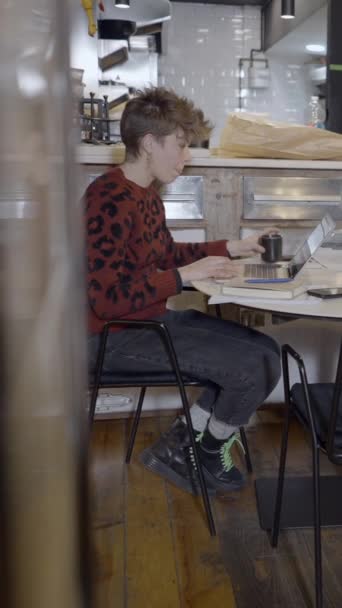 Kortharige Vrouw Drinkt Koffie Gebruikt Computer Leeg Restaurant Fullhd Verticale — Stockvideo