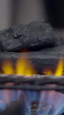 Mutfaktaki ocağın ızgarasında yanan kömürün yakın çekimi FullHD dikey video.