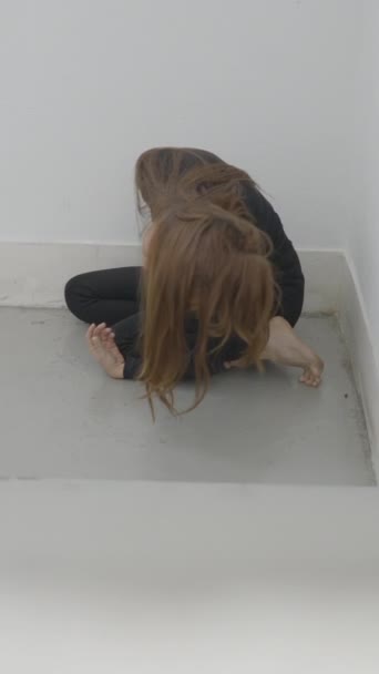 Young Woman Sits Corner Stairwell Moves Hair Face 1080 Vertical — Stock Video