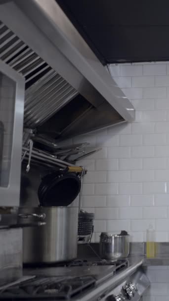 カウンターのスロープアウトと金属レストランキッチンのストーブ フルHd垂直ビデオ — ストック動画