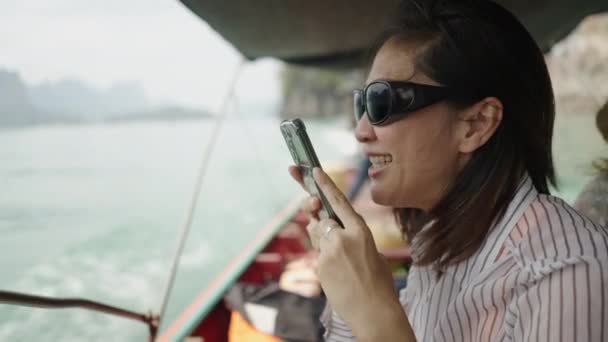 オーディオメッセージを送信するサングラスを身に着けている女性 横4Kビデオ — ストック動画