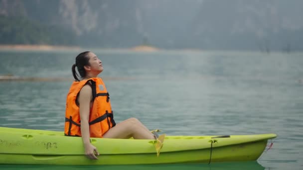一名妇女乘坐皮划艇在湖上放松 水平4K视频 — 图库视频影像