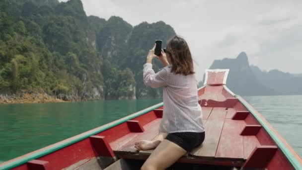 木製のボートで女性が湖の写真を撮る 水平4Kビデオ — ストック動画