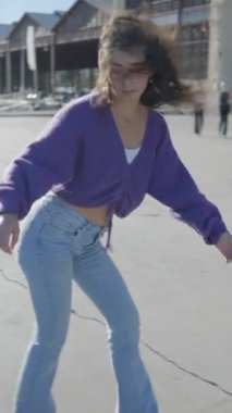 Güneşli limanda paten kayan kızın yakın Slomo 'su FullHD Dikey Video