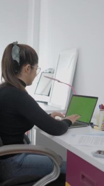 Uzaktan çekilen bir fotoğraf, masada oturan ve bilgisayarında hızla yazan genç bir kız. Kolombiya Üniversitesi 'nde okuyan bir öğrenci. - 1080 dikey video