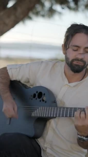 大胡子男子在车前室外弹吉他 在路边唱节奏敏捷的歌曲 垂直Fullhd视频 — 图库视频影像