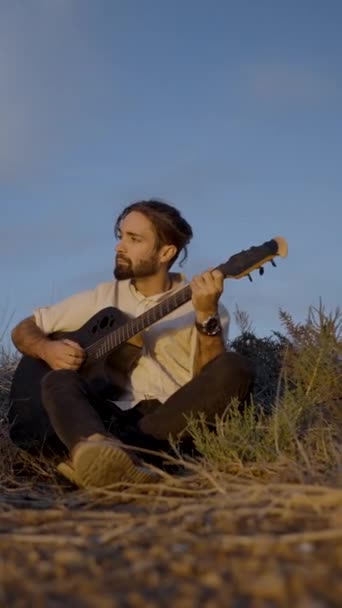 Pensive Bearded Hipster Man Sitting Louadow Playing Guitar Blue Sky — Stock video