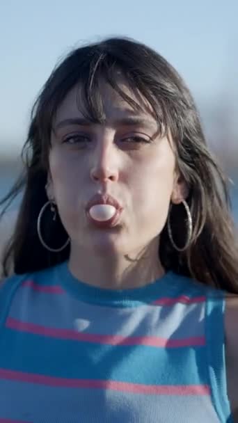 Tvář Tmavovlasé Dívky Foukající Bublinu Žvýkačkou Venku Fullhd Vertikální Video — Stock video