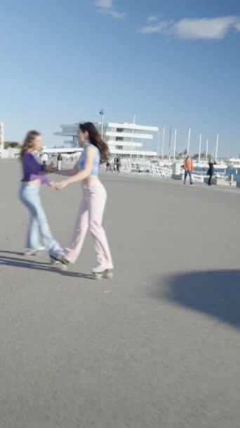 Две Девушки Держатся Руки Вращаются Вокруг Роликовые Коньки Солнечном Свете — стоковое видео