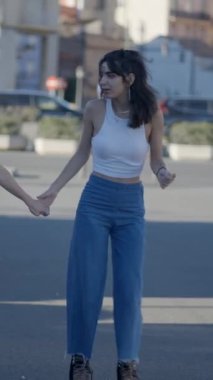 Kameraya doğru kayan iki siyah saçlı kızın Slomo 'su FullHD dikey video.