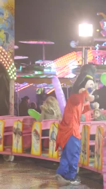 バレンシアの楽しいフェア ミッキーマウスの衣装の男は トレンチャック アトラクションで電車に乗っている子供を楽しませます Fullhd垂直ビデオ — ストック動画