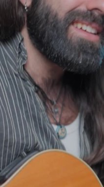 Young bearded and long-haired musician performing one of his last songs online to his audience - Close up shot