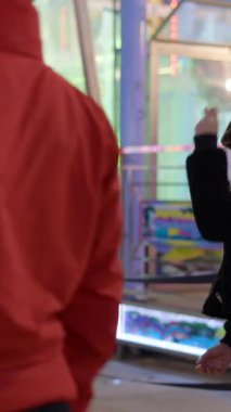 Valencia Funfair 'de kağıt taş makas oynayan iki genç kız gece FullHD dikey video oyunu