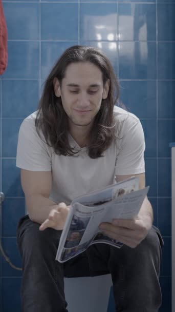 Young Caucasian Man Reading Newsletter Bathroom While Shit Frontal Shot — Vídeo de Stock