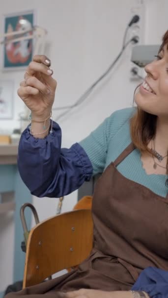 若い起業家 ペットのための宝石を作ることは彼女の職場でエプロンを着ています フルHdの垂直ビデオを閉じる — ストック動画