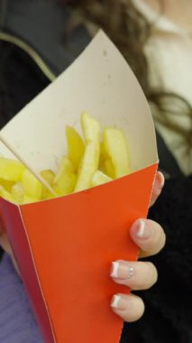İki kız arkadaş geceleyin Valencia Caddesi 'nde yemek yiyorlar - patates kızartması ve çikolatalı waffle - yüz ve eller - FullHD dikey video