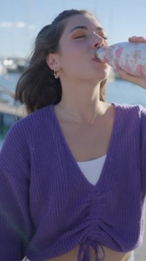 Mor bluzlu, limanlı, şişeden su içen kızın Slomo 'su.