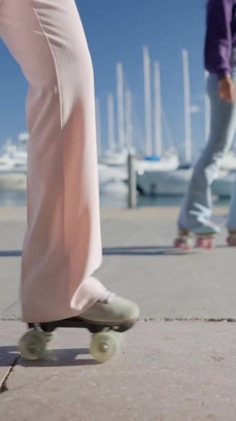 ピンクのズボンの少女はボート スロモでレトロなローラーのスケートにステップを取ります フルHd垂直ビデオ — ストック動画
