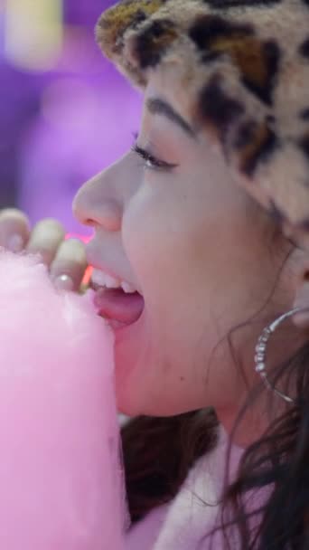 游乐园内可爱的年轻女子咬粘粉红糖果牙线的脸 Fullhd垂直录像 — 图库视频影像