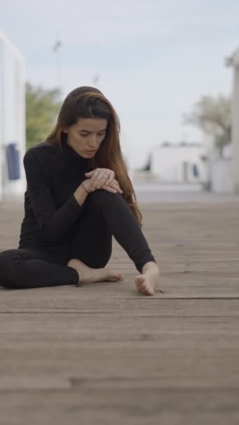 黒い服を着た若い女性はショックを受け プッシュイン見て屋外に座る 1080 垂直ビデオ — ストック動画
