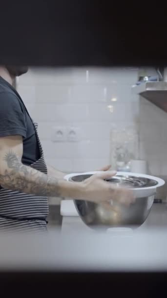 壁に穴を通して見たレストランキッチンで働く男性シェフ フルHd垂直ビデオ — ストック動画