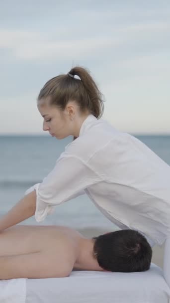 Widok Boku Profesjonalnego Kosmetyczki Wykonującego Masaż Plaży Młodego Mężczyzny Fullhd — Wideo stockowe