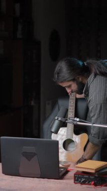 Young hipster musician teaching his student online each part that a guitar has - American shot