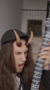 Çılgın gitarist oyuncak elektro gitar çalıyormuş gibi yapıyor. Yavaş çekim - 1080 Dikey video