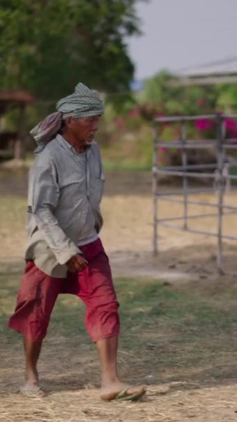 一名身穿绿色和红色衣服的男子穿过农场 Fhd垂直录像 — 图库视频影像