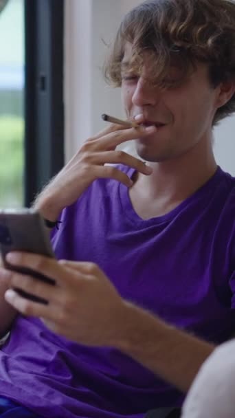 Homem Loiro Fuma Olha Para Algo Seu Telefone Fullhd Vertical — Vídeo de Stock