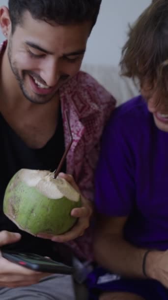 2人の石打ちの友人がココナッツを飲んでセルフィーを取る Fullhd垂直ビデオ — ストック動画
