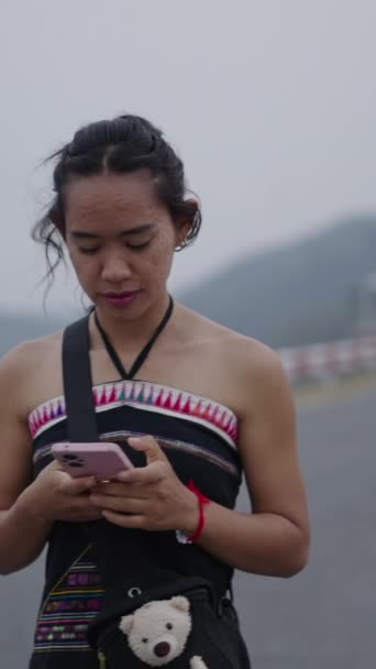 Uma Menina Olha Para Seu Telefone Celular Uma Estrada Montanha — Vídeo de Stock
