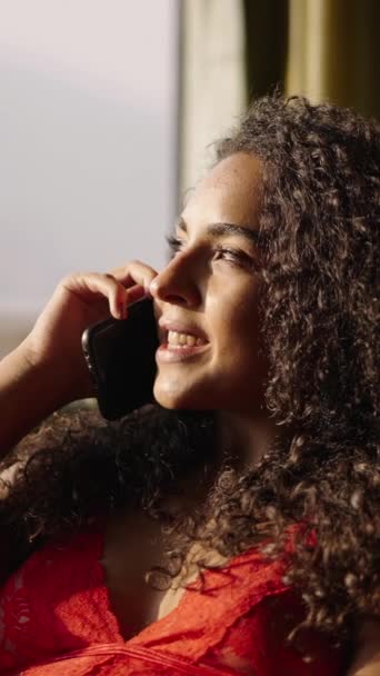 Chica Latina Sonriente Habla Teléfono Móvil Iluminado Por Luz Ventana — Vídeos de Stock