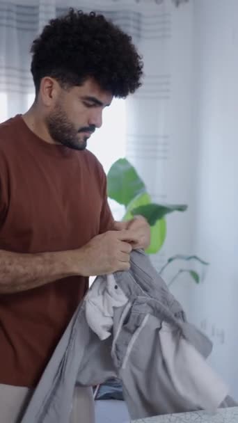 Pria Latin Berkonsentrasi Pada Menyetrika Celananya Video Vertikal Fhd — Stok Video