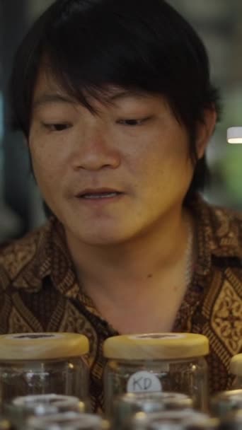 Asijský Muž Ukazuje Typy Trávy Zákazníkům Fullhd Vertikální Video — Stock video