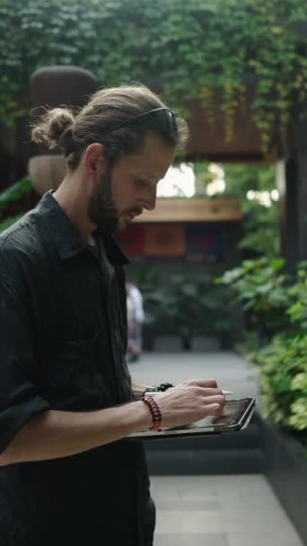 Homem Caucasiano Desenhando Algo Seu Tablet Jardim Fhd Vídeo Vertical — Vídeo de Stock