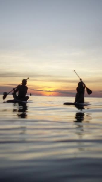남성과 여자는 일몰에 해안을 보드를 Fhd — 비디오
